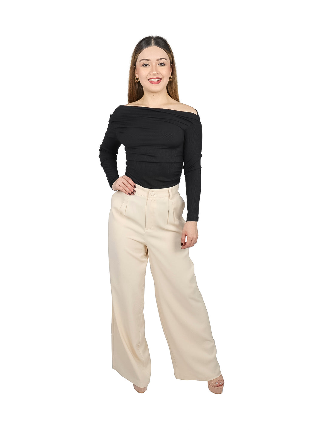 Mujer vistiendo blusa negra de manga larga con hombros descubiertos y pantalones color crema.