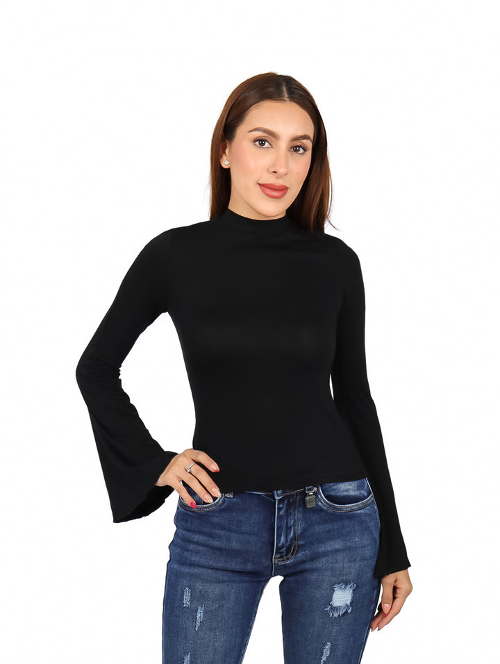 Mujer modelando blusa negra de manga campana y cuello alto con pantalones de mezclilla azules.