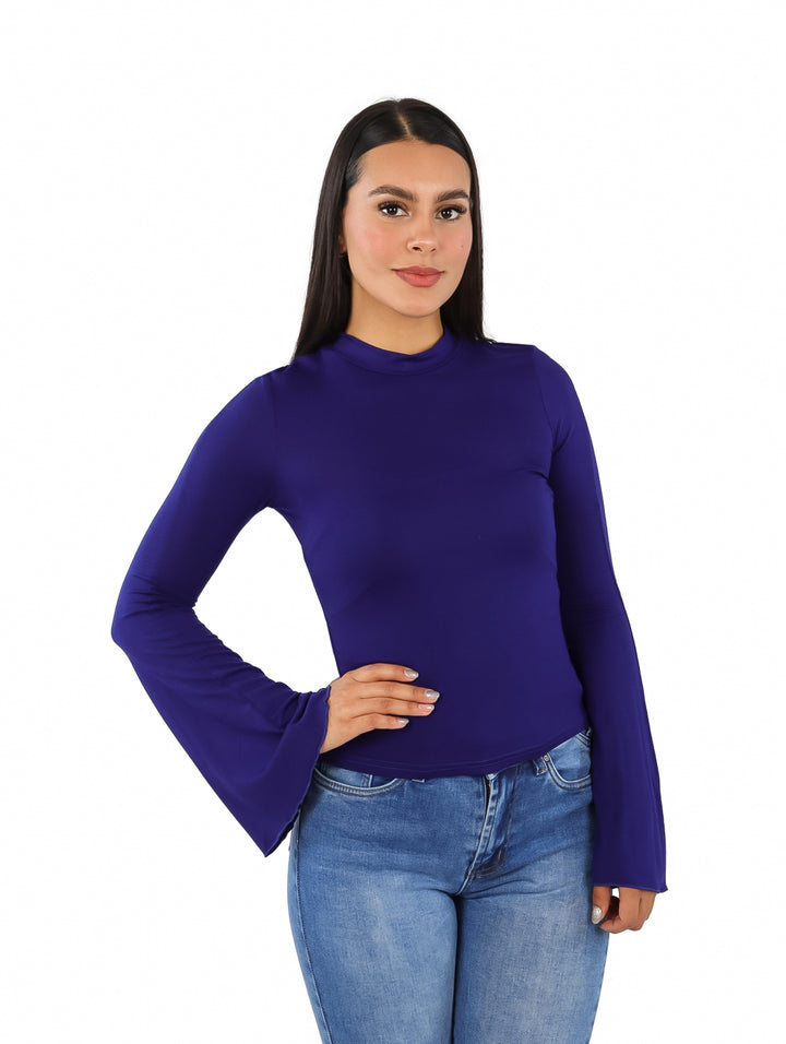 Mujer vistiendo blusa color navy con mangas acampanadas y pantalones de mezclilla.