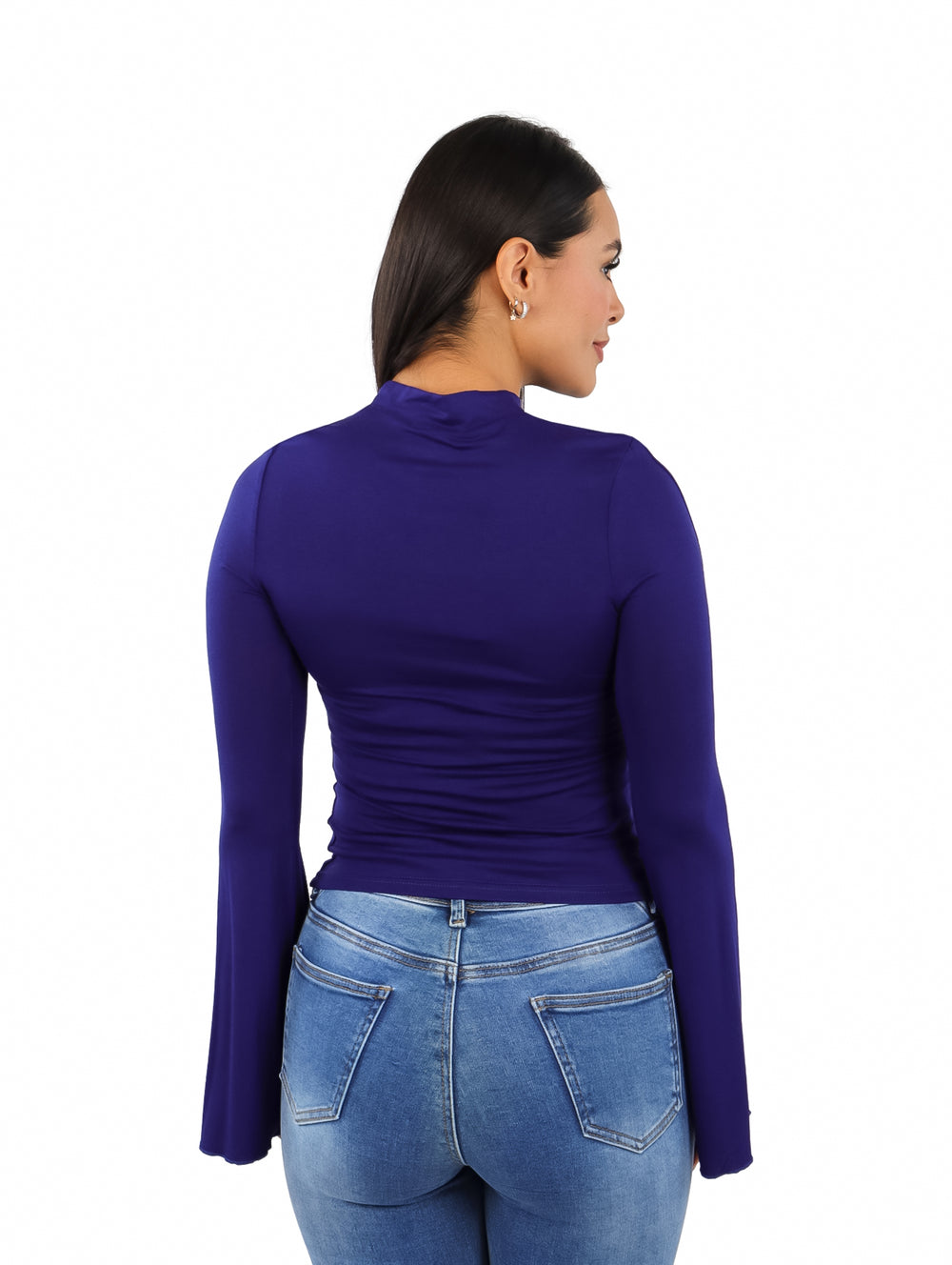 Mujer vistiendo blusa color navy con mangas acampanadas y pantalones de mezclilla.