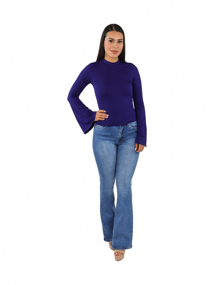 Mujer vistiendo blusa color navy con mangas acampanadas y pantalones de mezclilla.