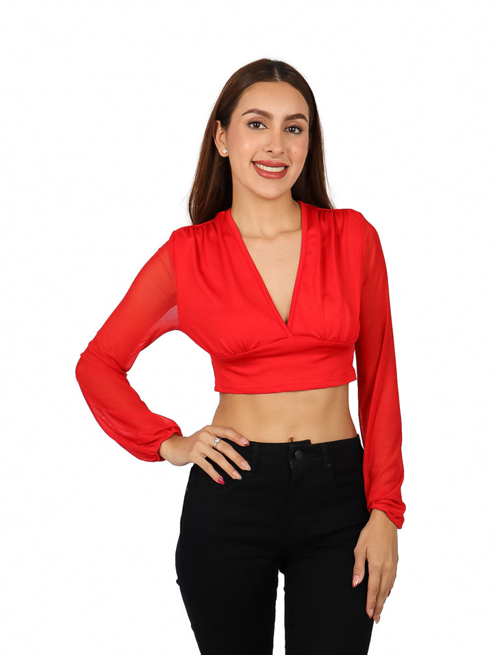 Mujer vistiendo una blusa roja corta con escote en V y mangas largas.