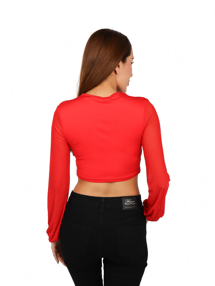 Mujer vistiendo una blusa roja corta con escote en V y mangas largas.