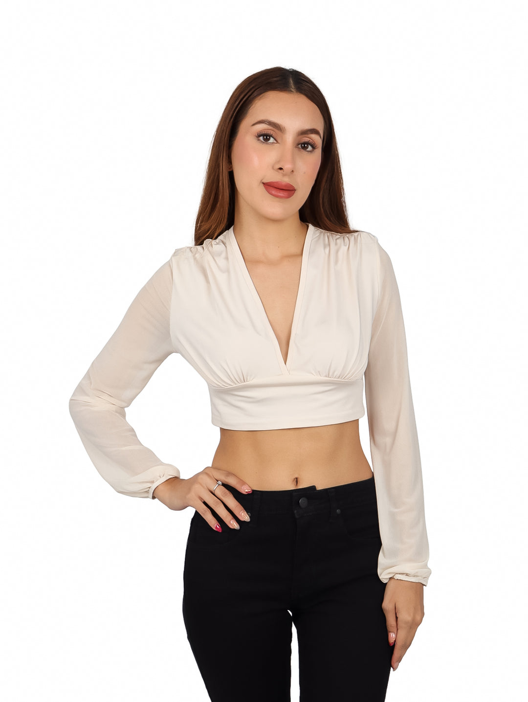 Mujer vistiendo blusa corta color arena con escote en V y manga larga, combinada con pantalones negros.