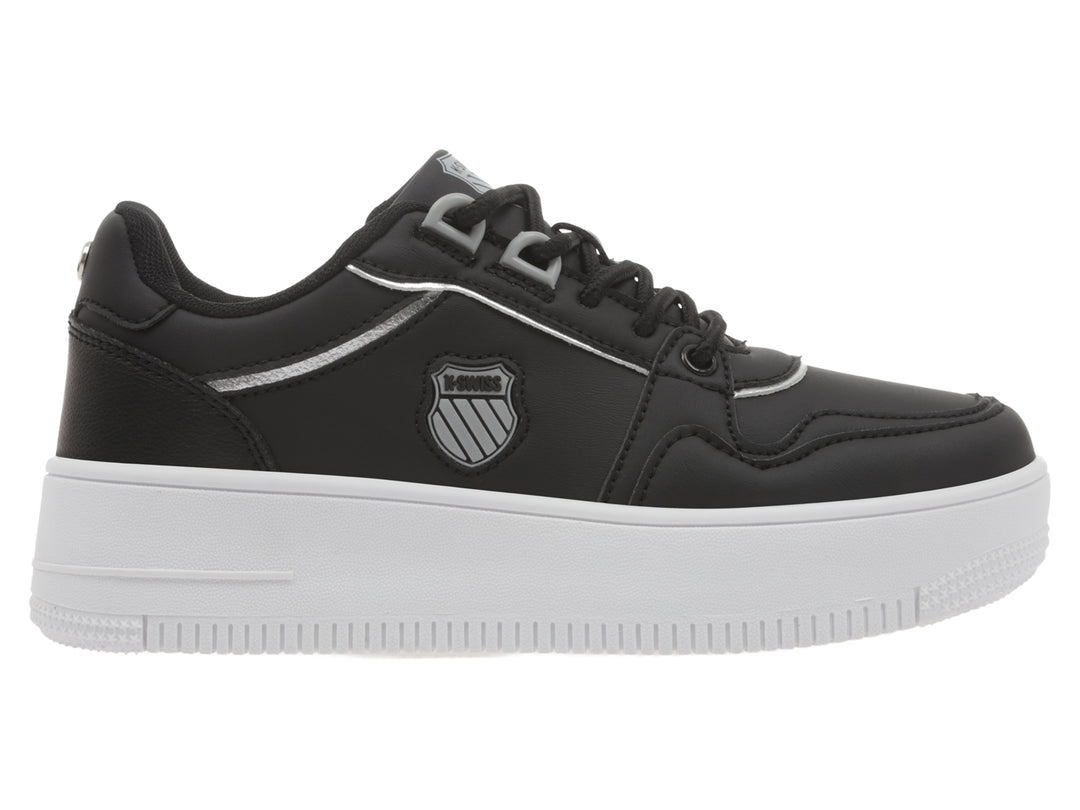 Tenis K-Swiss color negro con suela de plataforma blanca y detalles en plata.