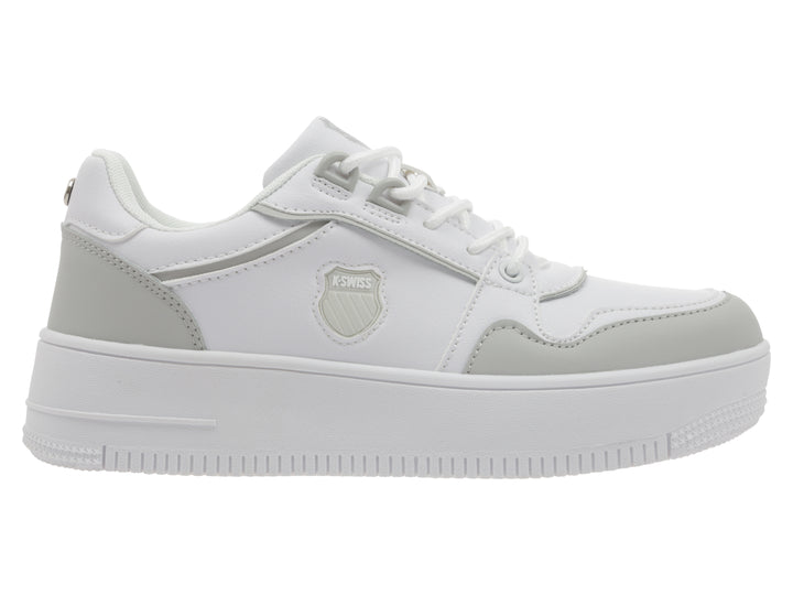 Tenis K-Swiss blancos con detalles en gris y suela de plataforma blanca.