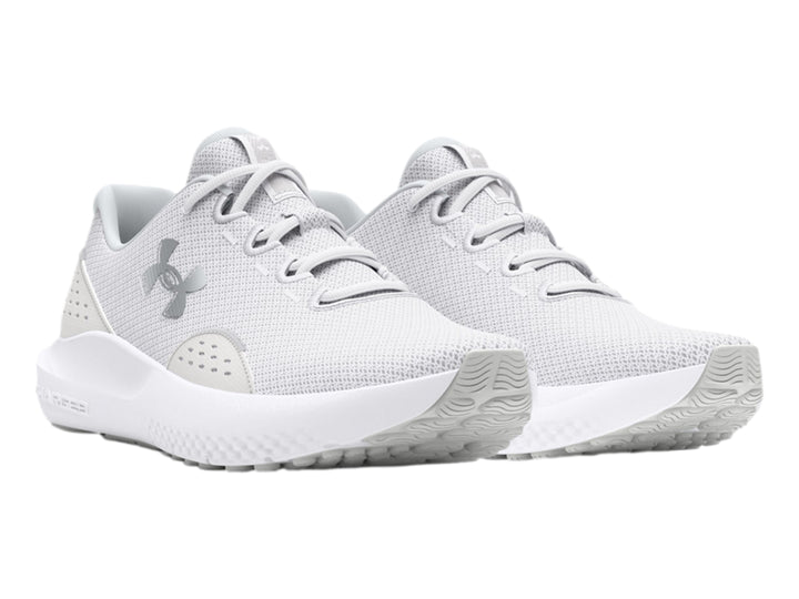 Tenis deportivos Under Armour Charged Surge 4 en color blanco con malla transpirable y suela blanca.