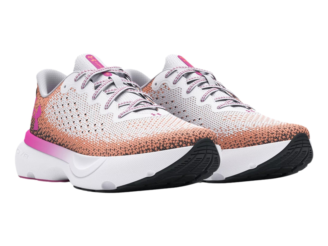 Tenis deportivos Under Armour blancos con degradado en rosa y naranja y suela blanca.