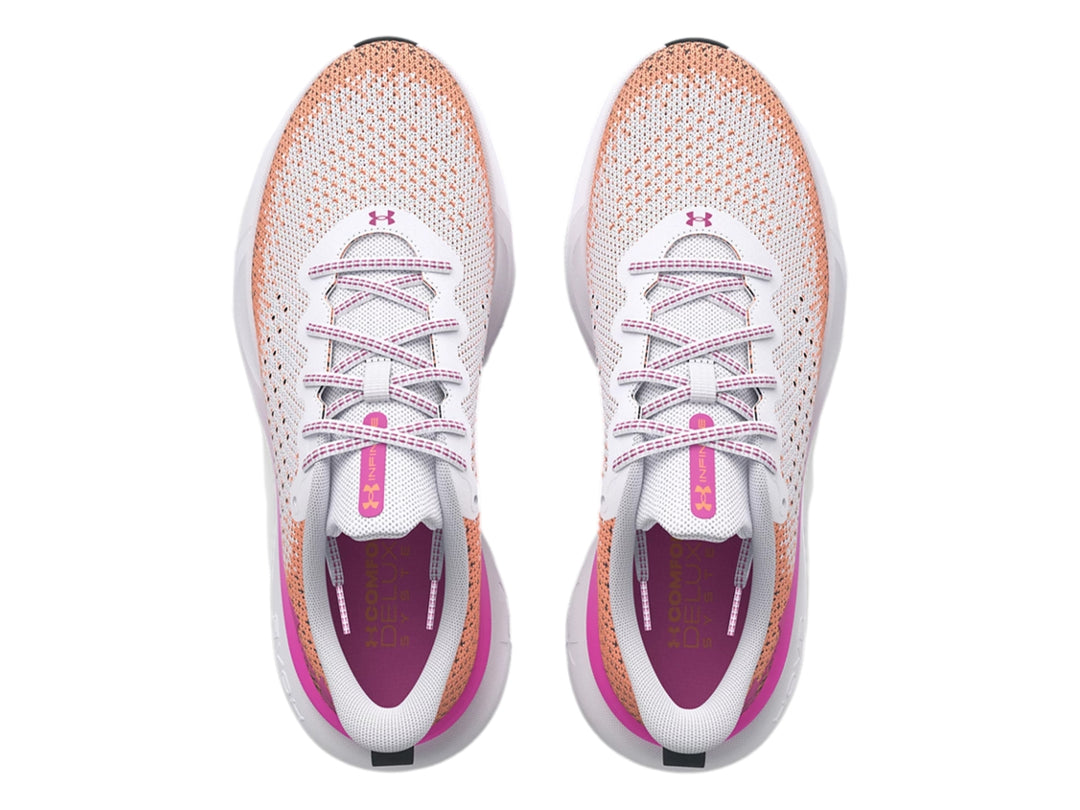 Tenis deportivos Under Armour blancos con degradado en rosa y naranja y suela blanca.