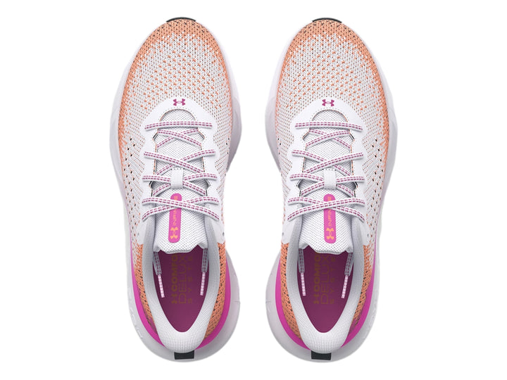 Tenis deportivos Under Armour blancos con degradado en rosa y naranja y suela blanca.
