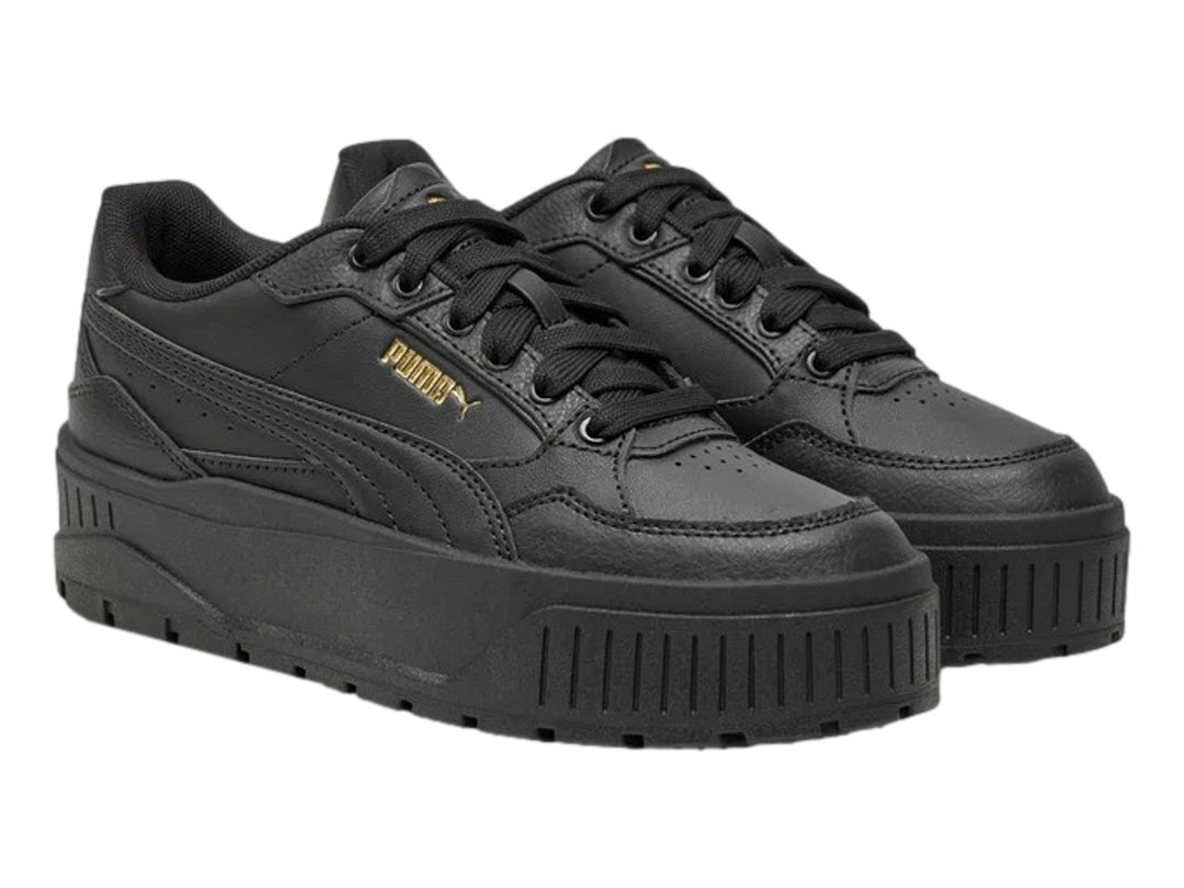 Tenis PUMA color negro con suela de plataforma gruesa y logotipo dorado en el lateral.