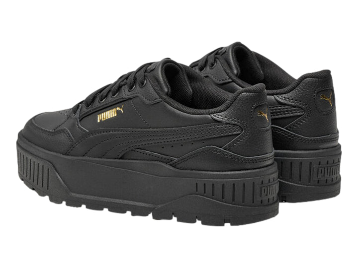 Tenis PUMA color negro con suela de plataforma gruesa y logotipo dorado en el lateral.