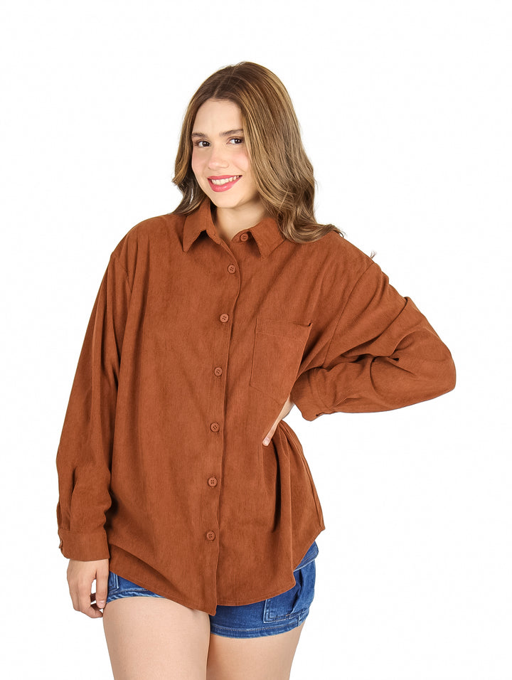 Mujer vistiendo una camisa marrón holgada de botones y manga larga.