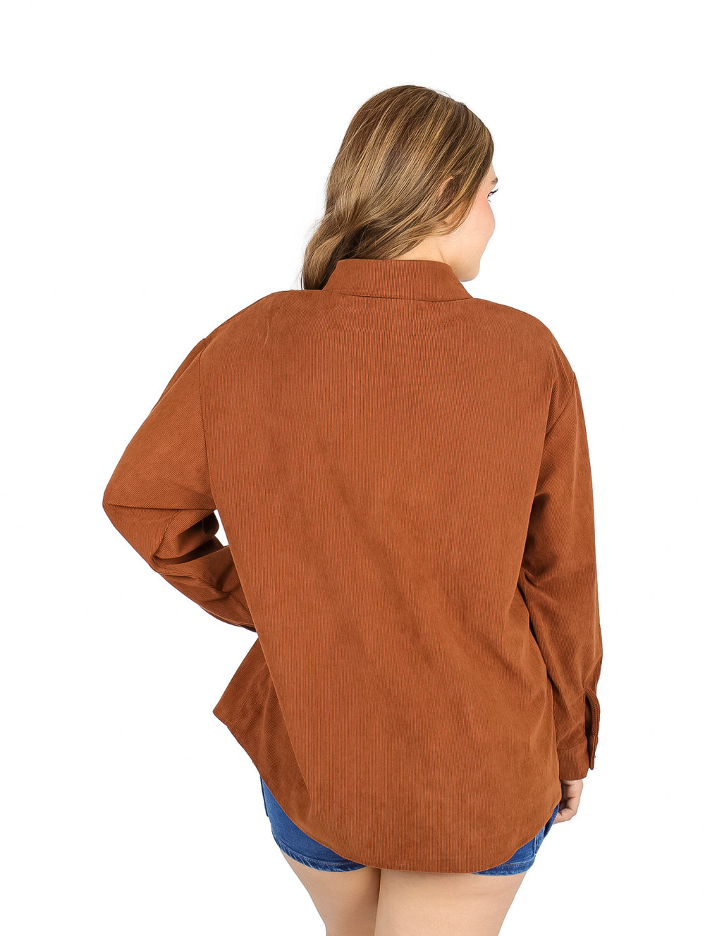 Mujer vistiendo una camisa marrón holgada de botones y manga larga.