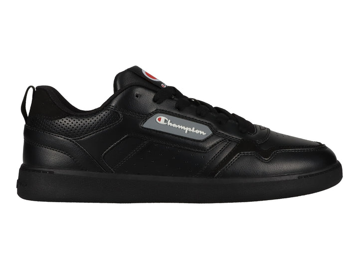 Tenis deportivos Champion color negro con suela plana y detalles perforados en el costado.