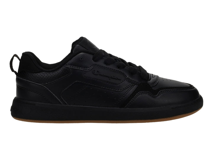 Tenis Champion color negro con suela de goma marrón, diseño deportivo de corte bajo.