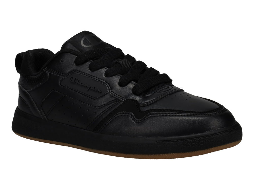 Tenis Champion color negro con suela de goma marrón, diseño deportivo de corte bajo.