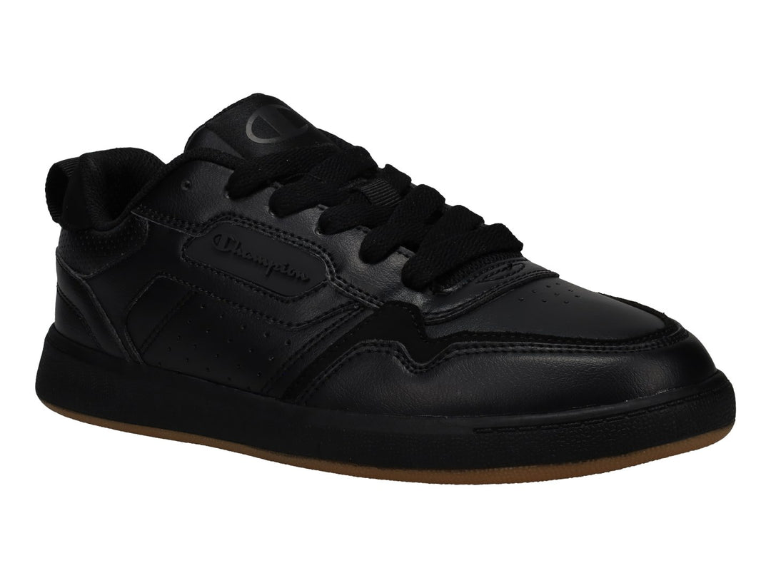 Tenis Champion color negro con suela de goma marrón, diseño deportivo de corte bajo.