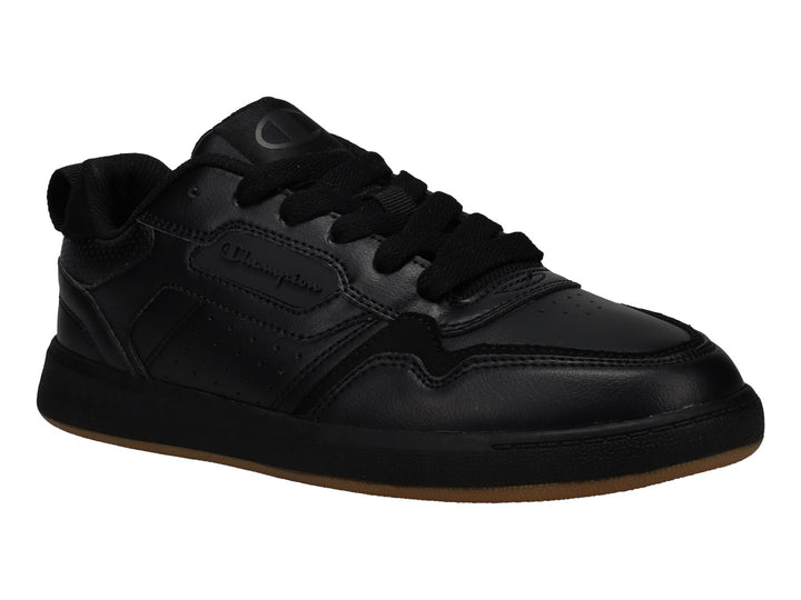 Tenis Champion color negro con suela de goma marrón, diseño deportivo de corte bajo.