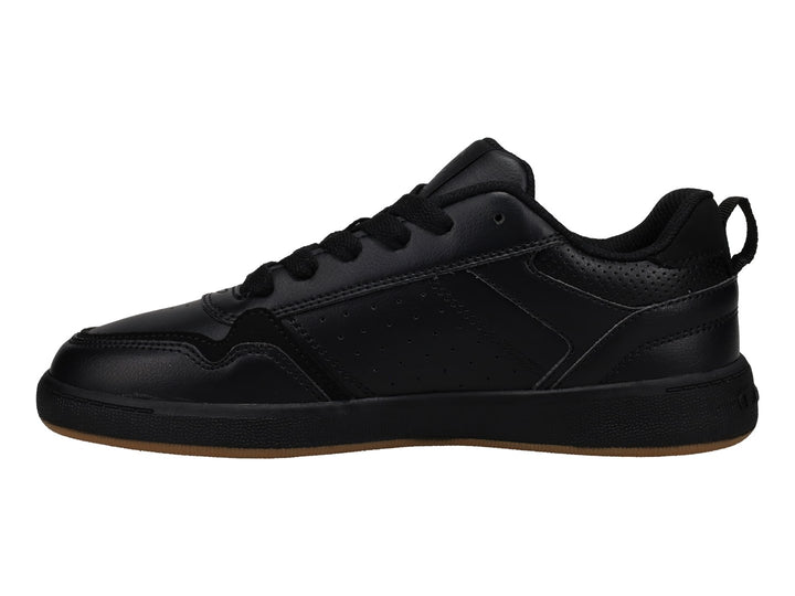 Tenis Champion color negro con suela de goma marrón, diseño deportivo de corte bajo.