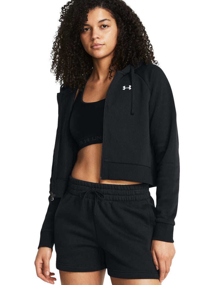 Mujer vistiendo una chaqueta deportiva negra corta con capucha y cierre frontal de Under Armour.