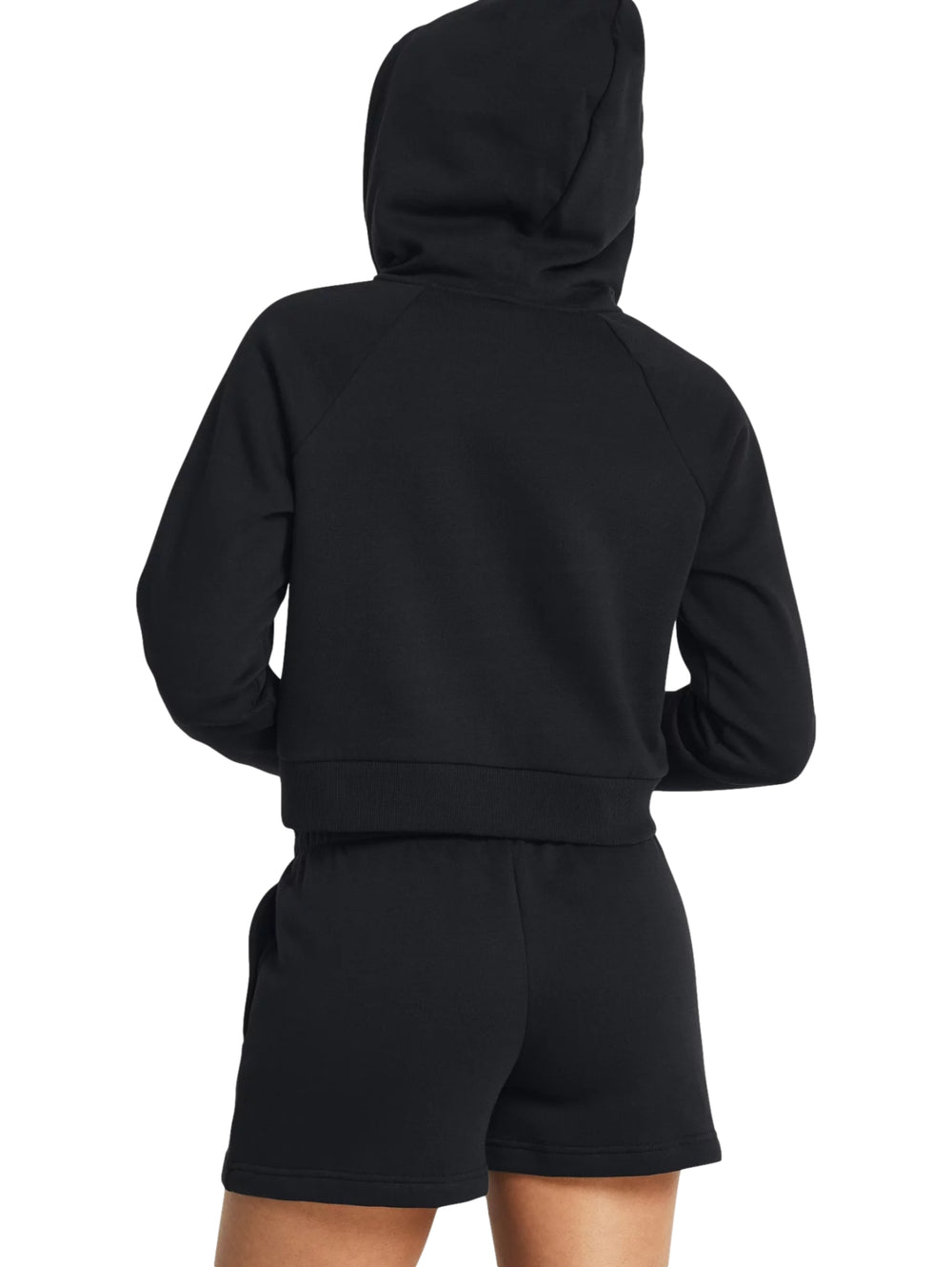 Mujer vistiendo una chaqueta deportiva negra corta con capucha y cierre frontal de Under Armour.