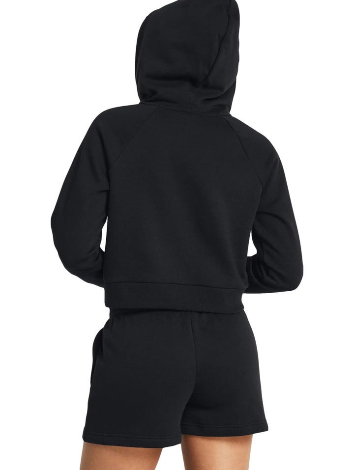 Mujer vistiendo una chaqueta deportiva negra corta con capucha y cierre frontal de Under Armour.
