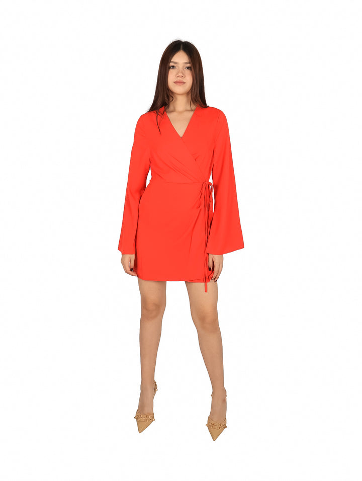 Mujer vistiendo un vestido corto color rojo con mangas largas y cuello en V.