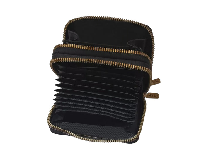 Cartera pequeña de color negro con textura rugosa, cierre perimetral y logotipo de Jeep en relieve.