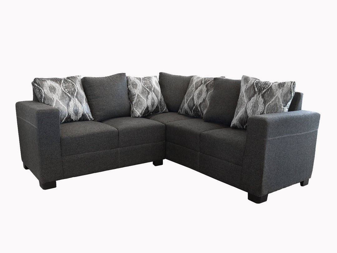 Sofá esquinero SFORNITURE color gris con cojines decorativos en tonos grises y blancos.