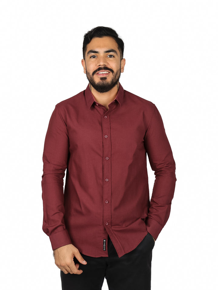 Hombre vistiendo una camisa de manga larga color vino con botones frontales.