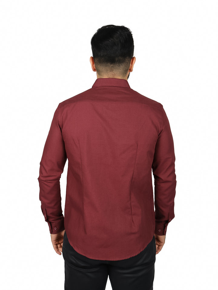 Hombre vistiendo una camisa de manga larga color vino con botones frontales.