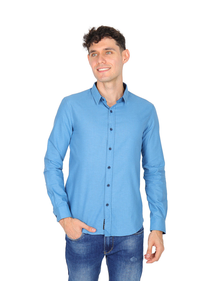 Hombre vistiendo una camisa azul de manga larga con botones y cuello, estilo casual.