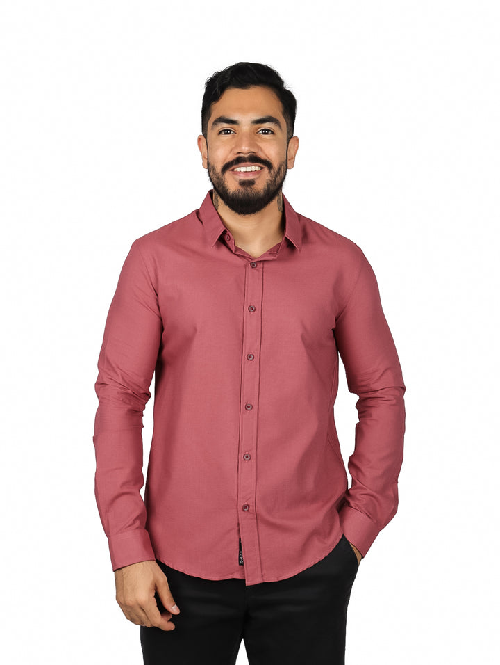 Hombre vistiendo una camisa de manga larga color terracota con botones frontales y cuello.
