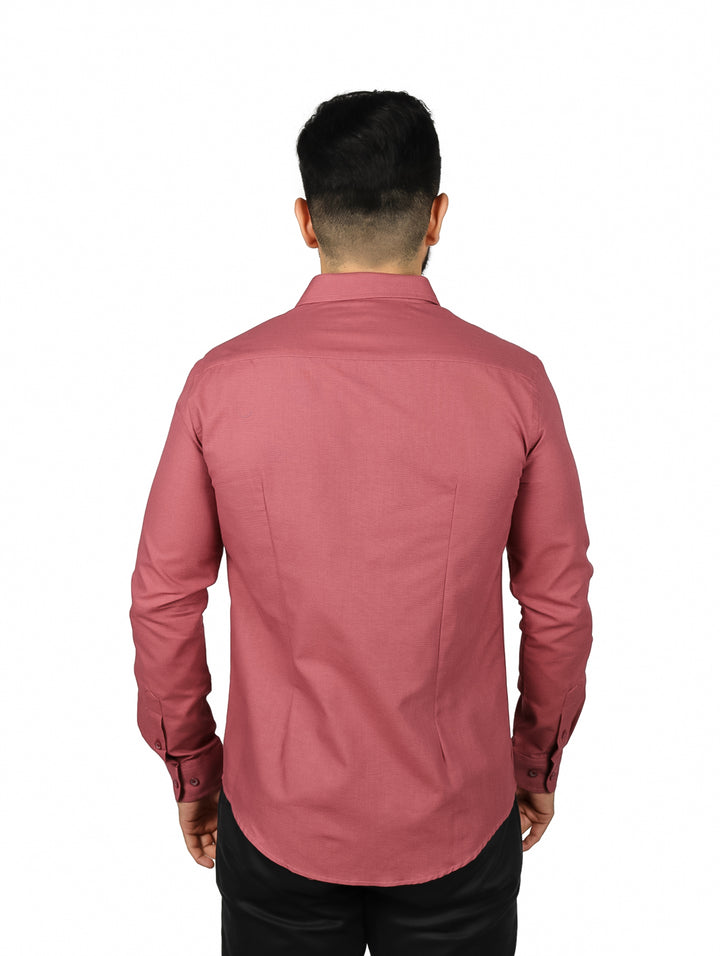 Hombre vistiendo una camisa de manga larga color terracota con botones frontales y cuello.