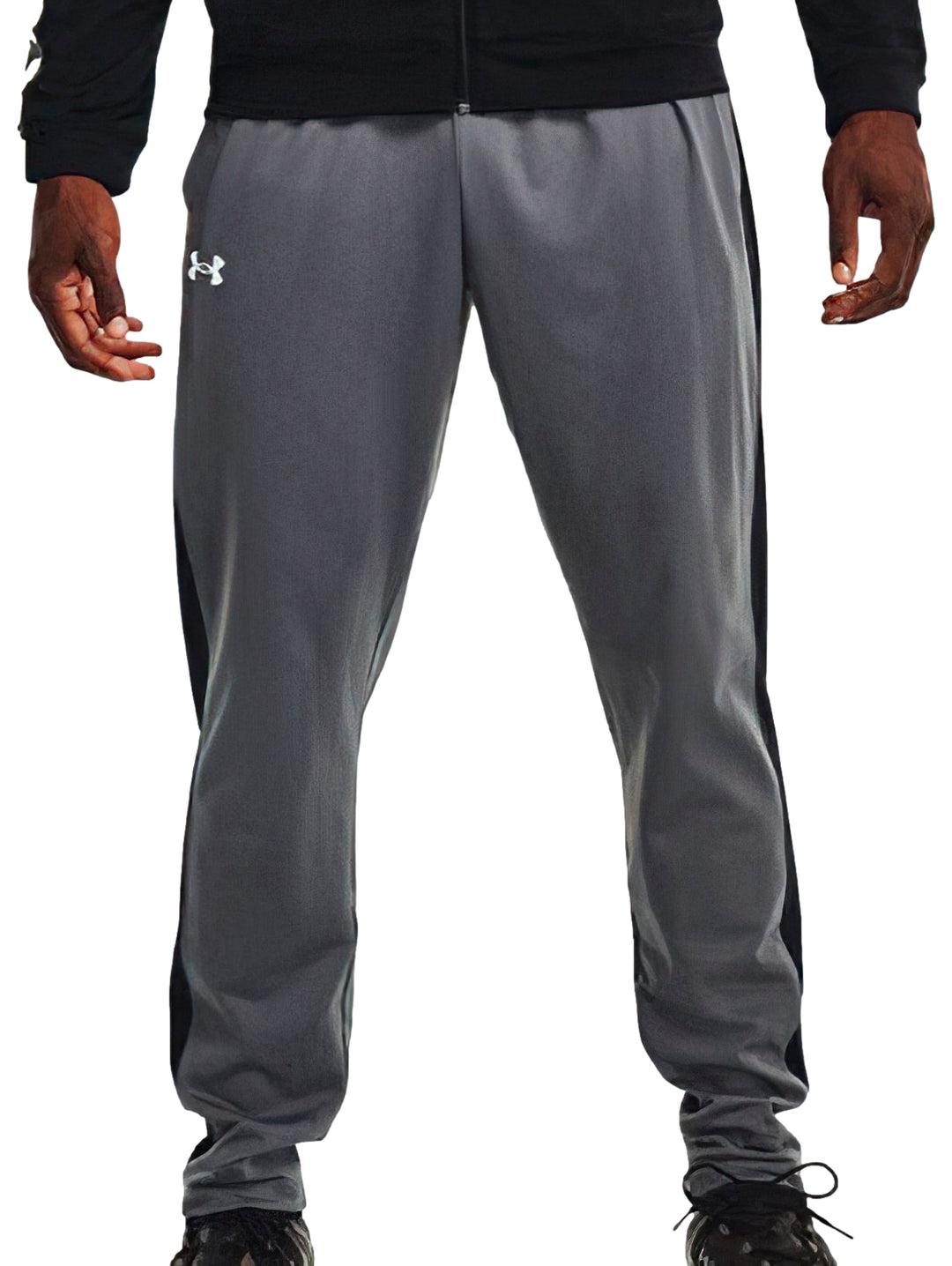Pantalones deportivos Under Armour en color gris con franjas negras laterales y logotipo blanco.