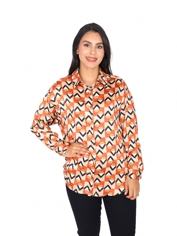 Mujer vistiendo camisa naranja con estampado geométrico y pantalones negros.