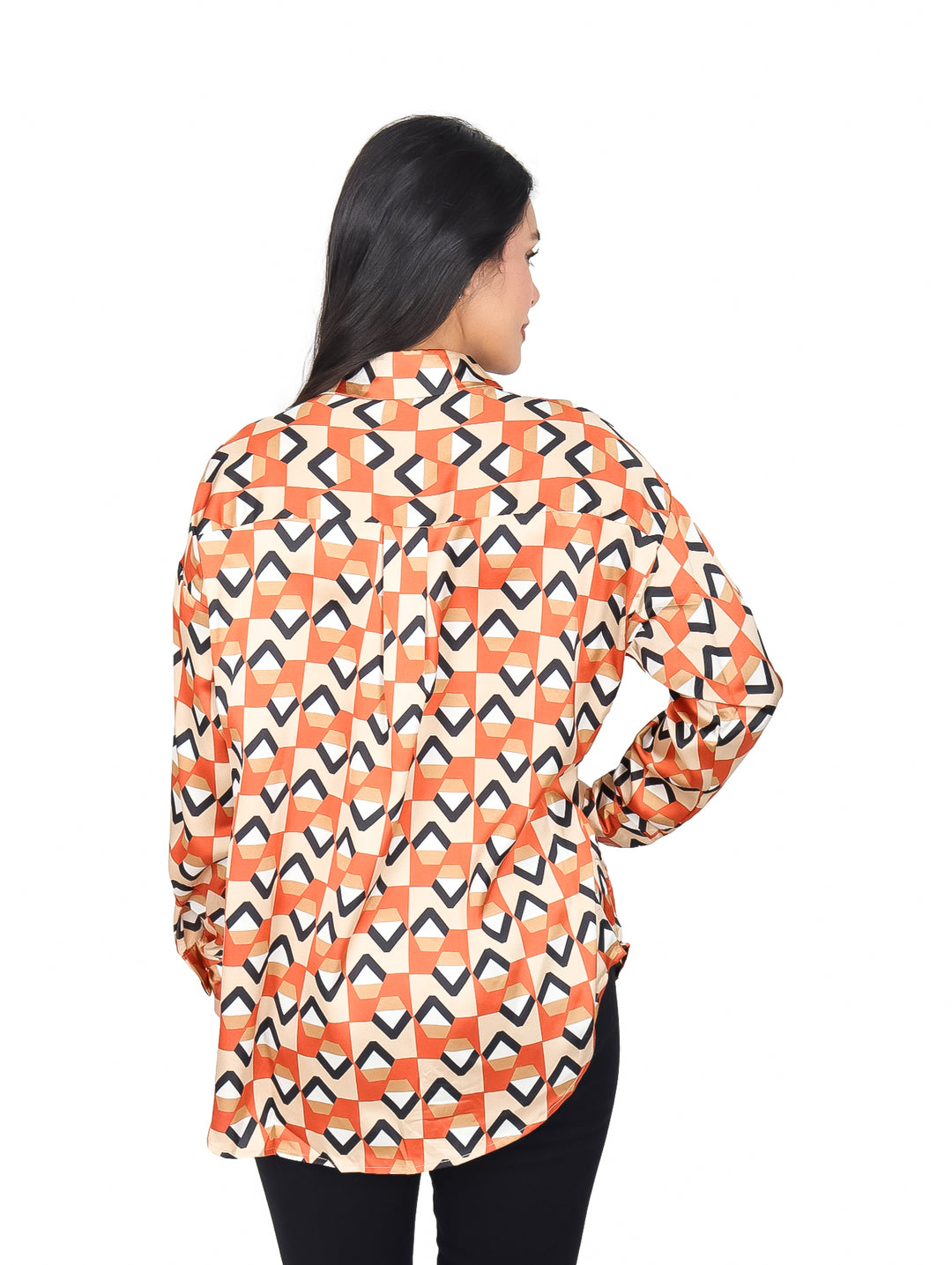 Mujer vistiendo camisa naranja con estampado geométrico y pantalones negros.