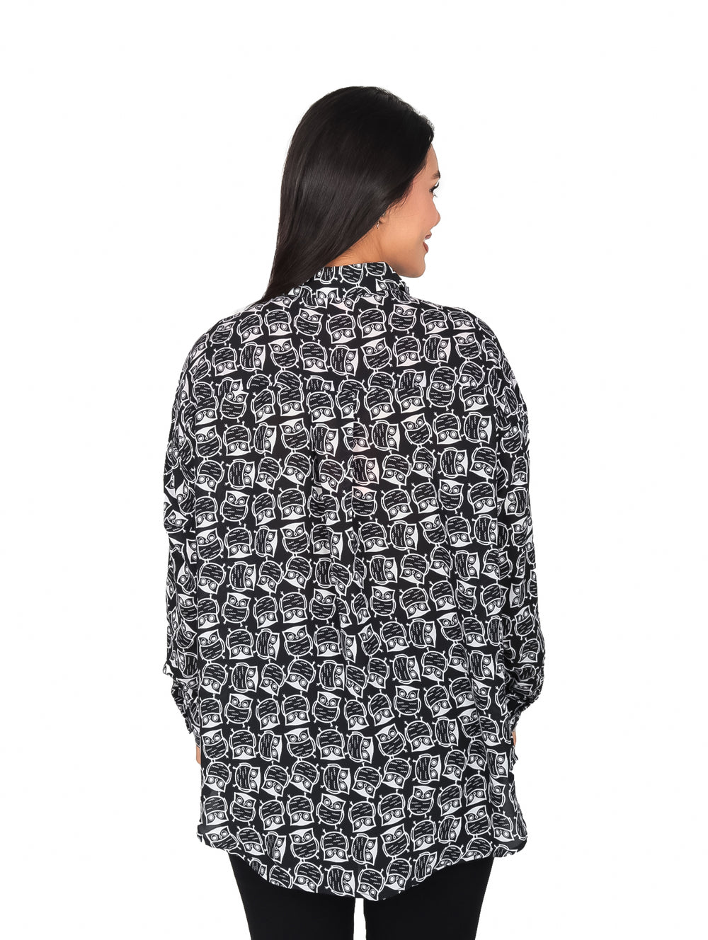 Mujer vistiendo camisa negra de manga larga con estampado blanco de búhos y cuello clásico.