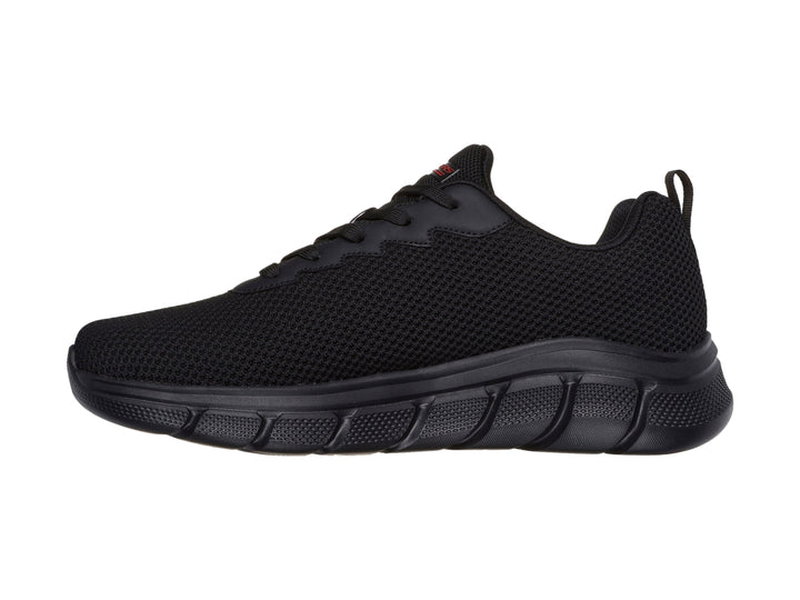 Tenis deportivos Skechers color negro con suela gruesa y detalles en rojo.
