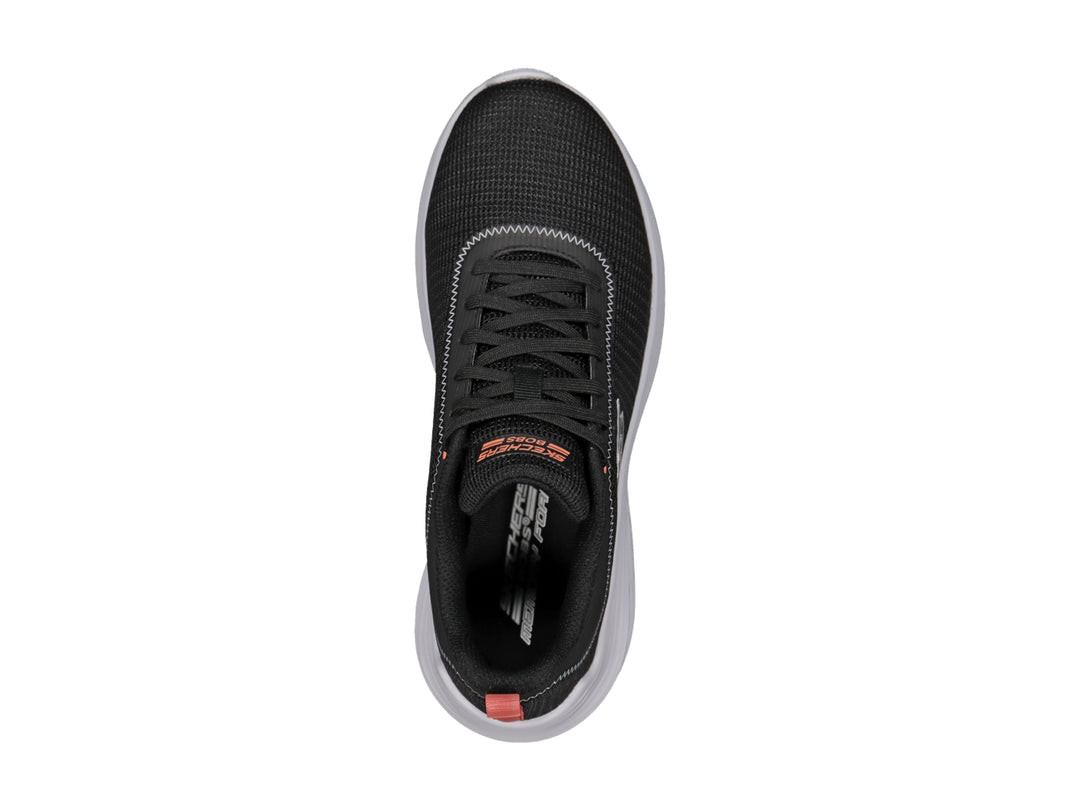 Tenis deportivos Skechers color negro con suela blanca y detalle naranja en el talón.
