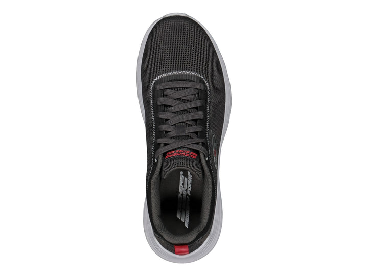 Tenis Skechers color gris con suela blanca y pequeña pestaña roja en el talón.