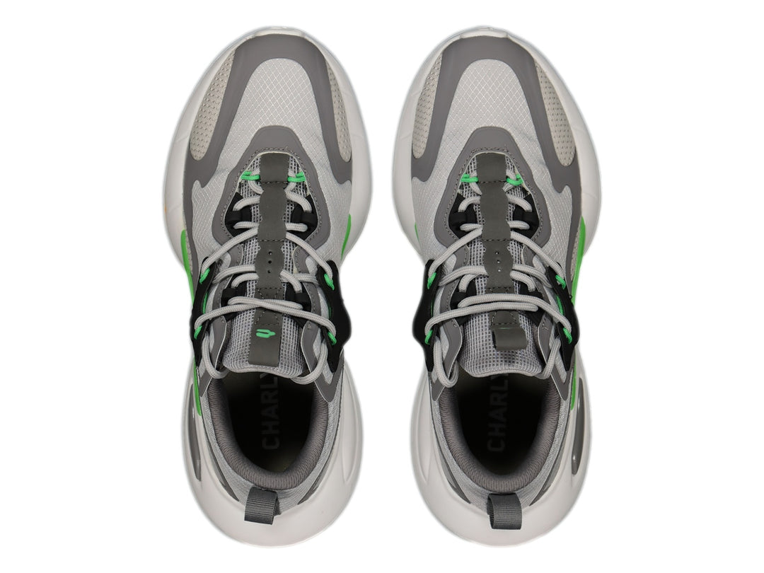 Tenis deportivos Charly en color gris con detalles en negro, blanco y verde lima, con suela blanca robusta.
