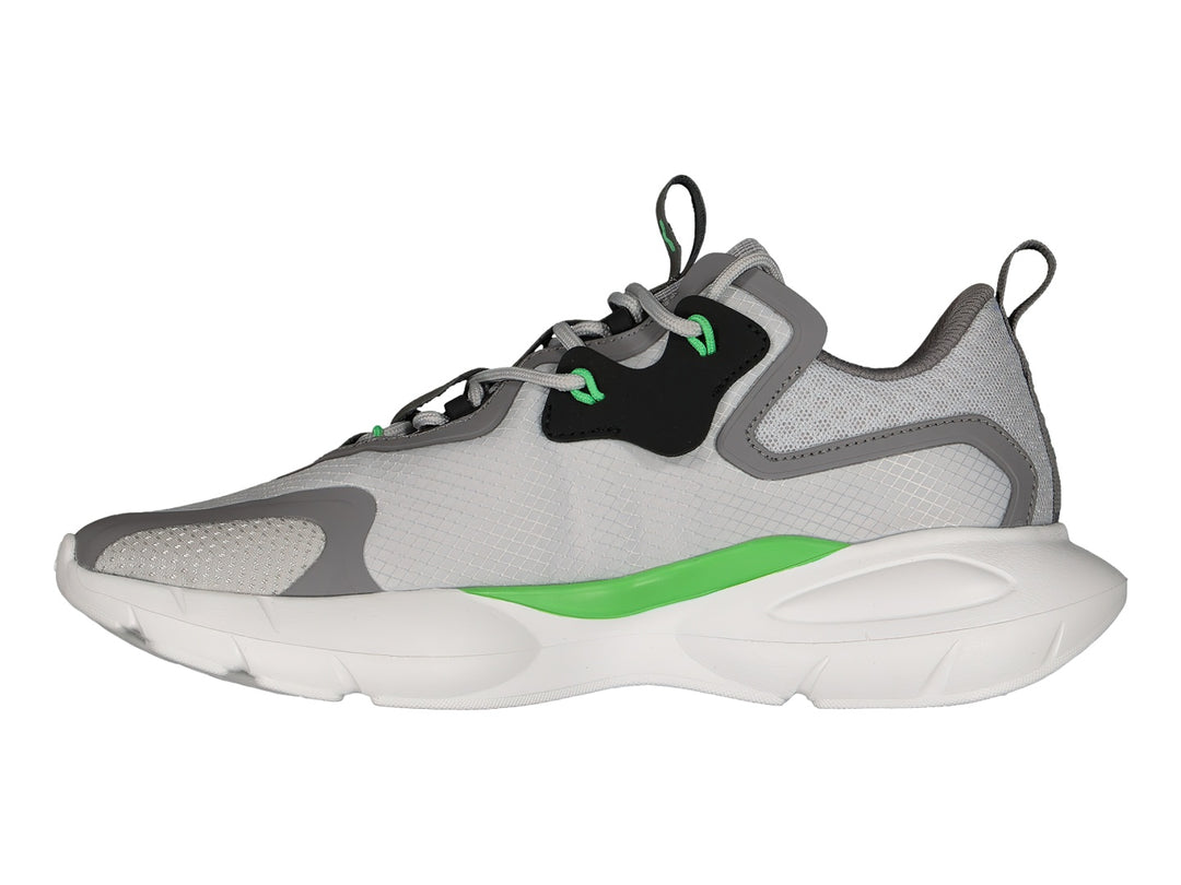 Tenis deportivos Charly en color gris con detalles en negro, blanco y verde lima, con suela blanca robusta.