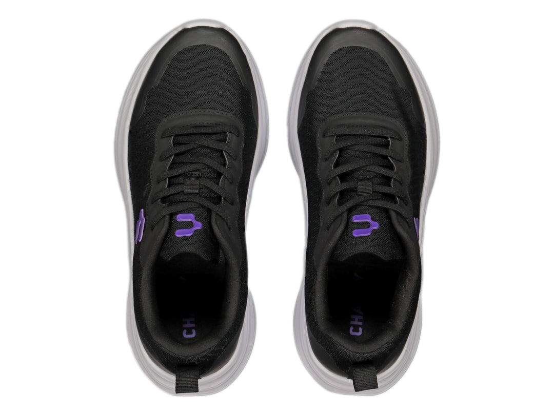 Tenis deportivos Charly color negro con suela blanca y logotipo morado en el lateral.