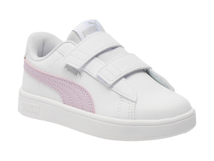 Tenis PUMA blancos con franja morada lateral y cierre de velcro.