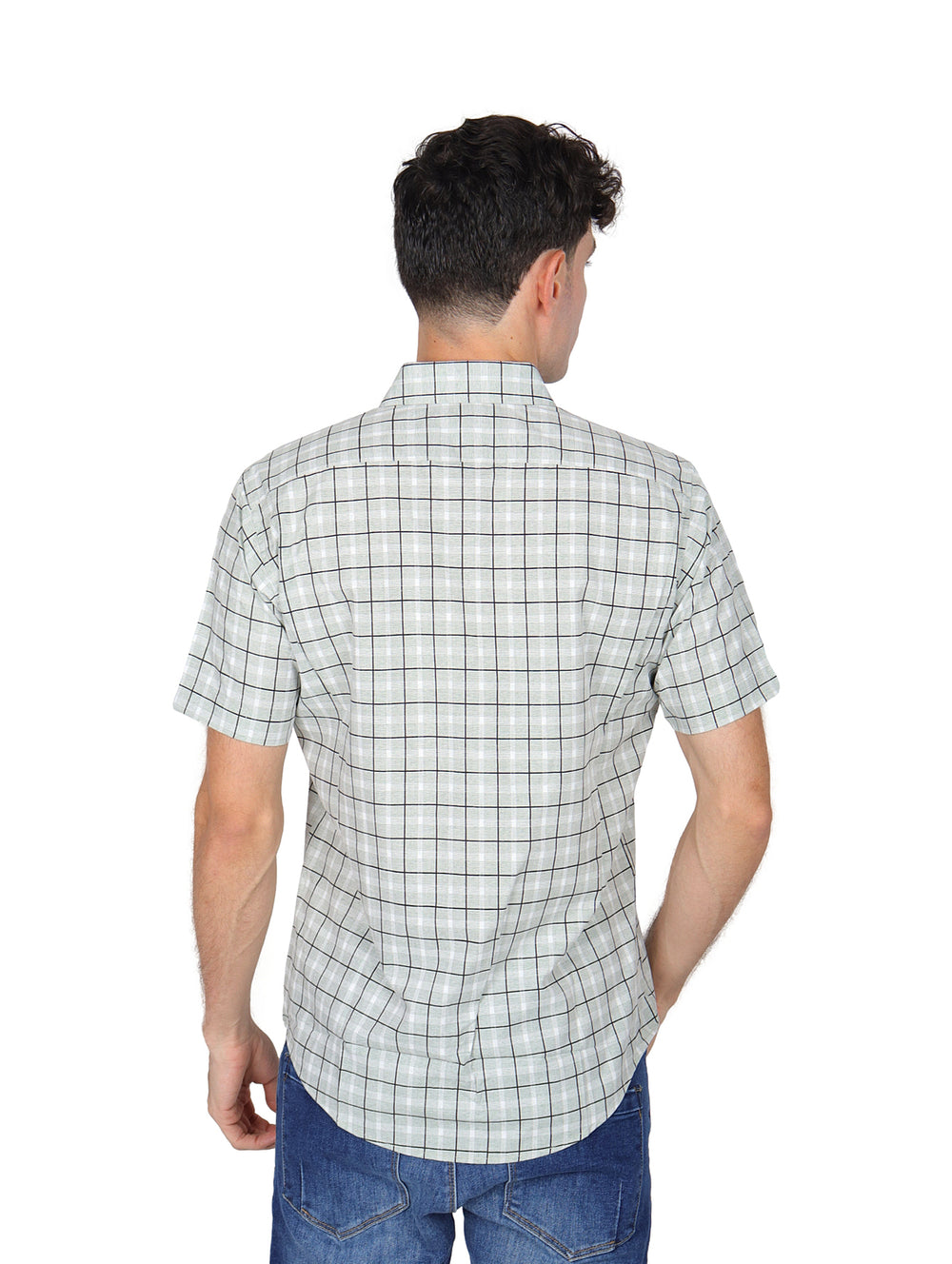 Hombre vistiendo una camisa blanca de manga corta con estampado de cuadros negros y pantalones jeans azules.