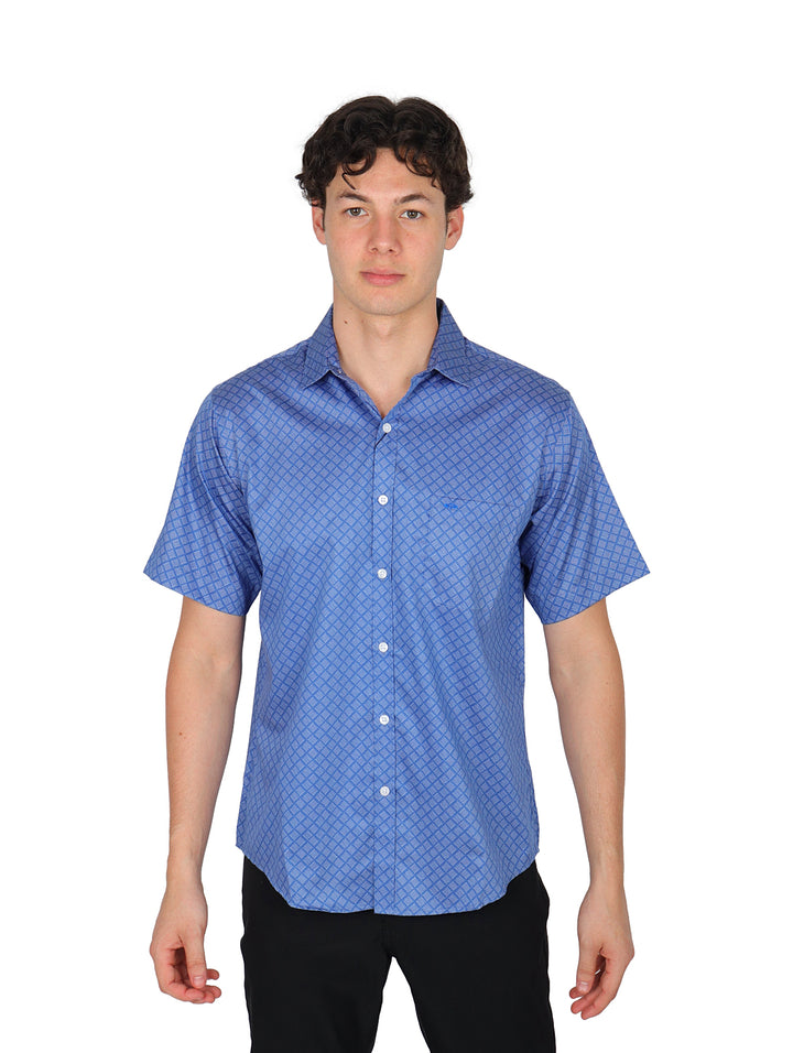 Hombre vistiendo una camisa azul de manga corta con estampado geométrico sutil y botones frontales.