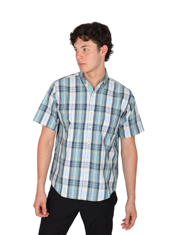 Hombre vistiendo camisa de manga corta con estampado de cuadros en tonos verde, blanco y azul.