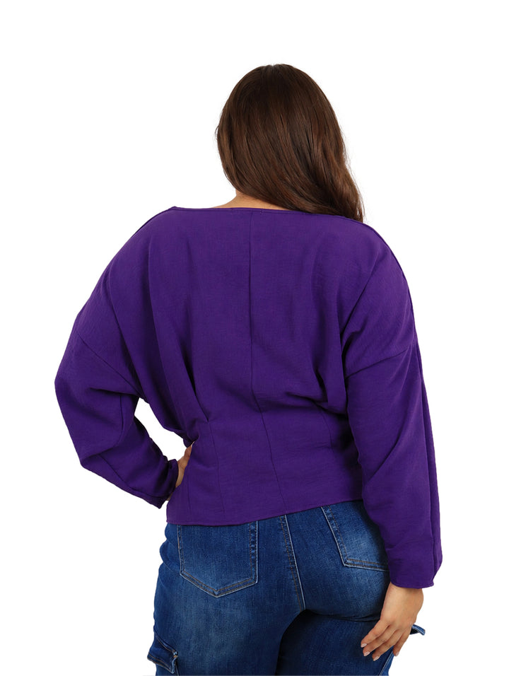Mujer vistiendo una blusa color uva de manga larga y cuello redondo.